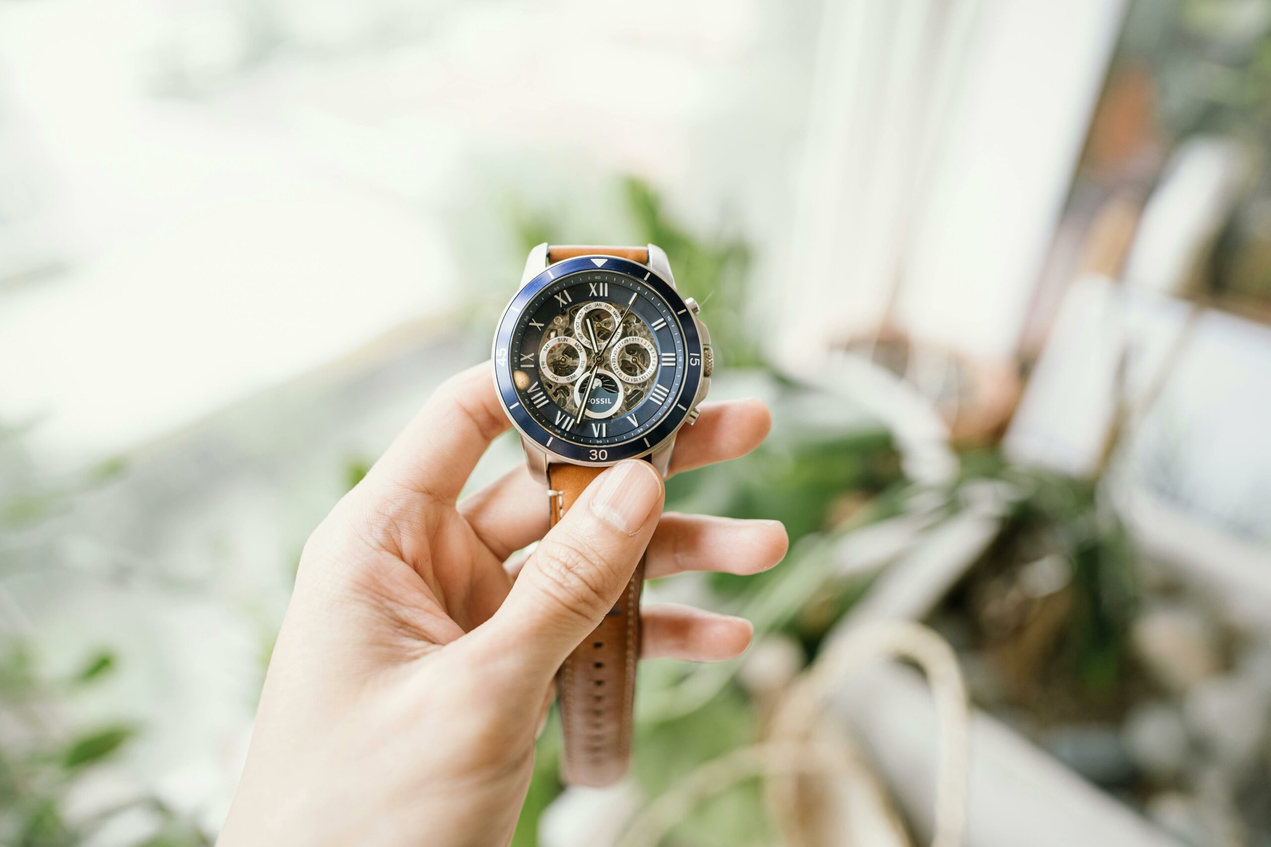 Person Hält Schwarze Und Orange Chronograph Uhr